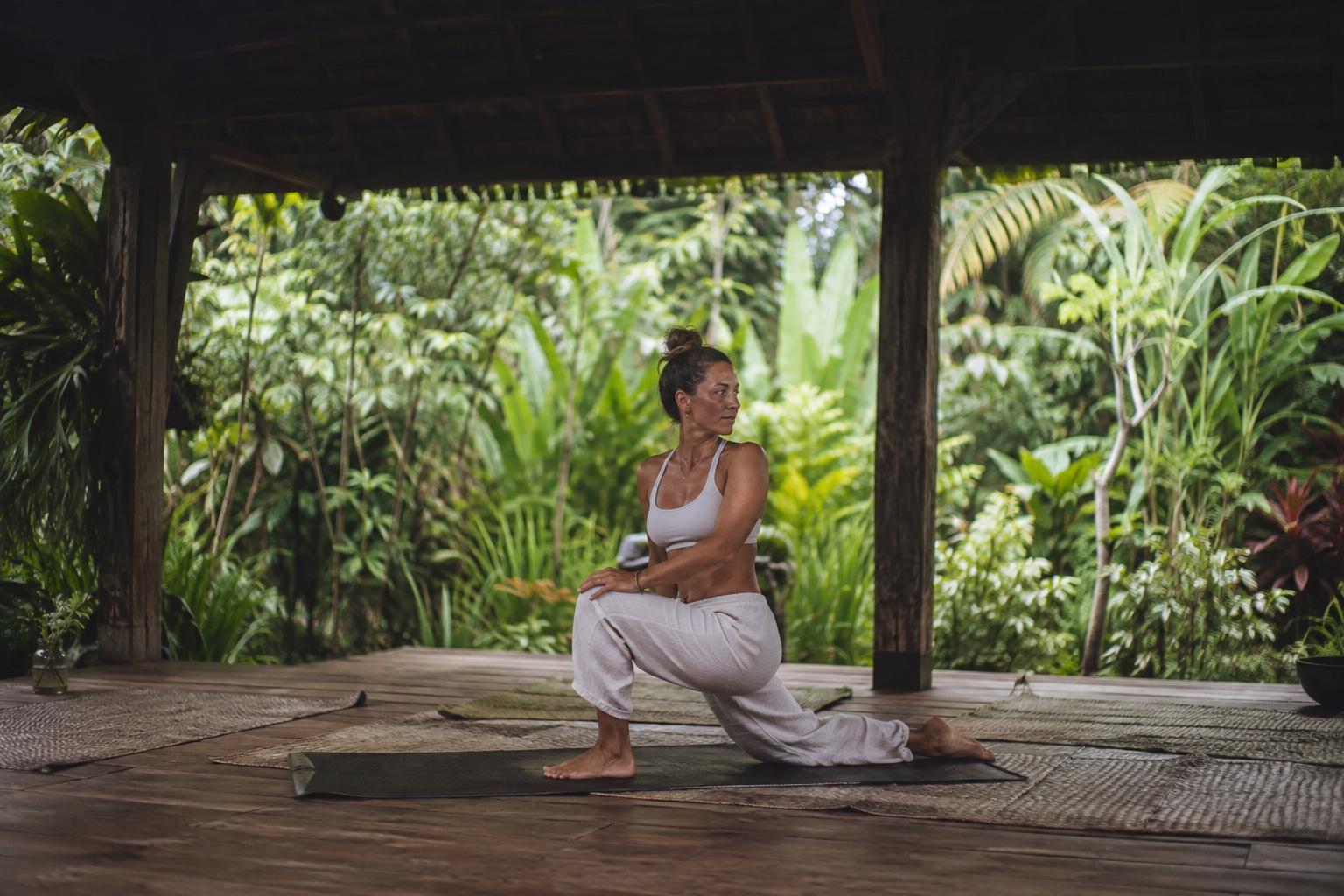 Yogainstruktör som håller ett pass i en grön yogastudio på Bali